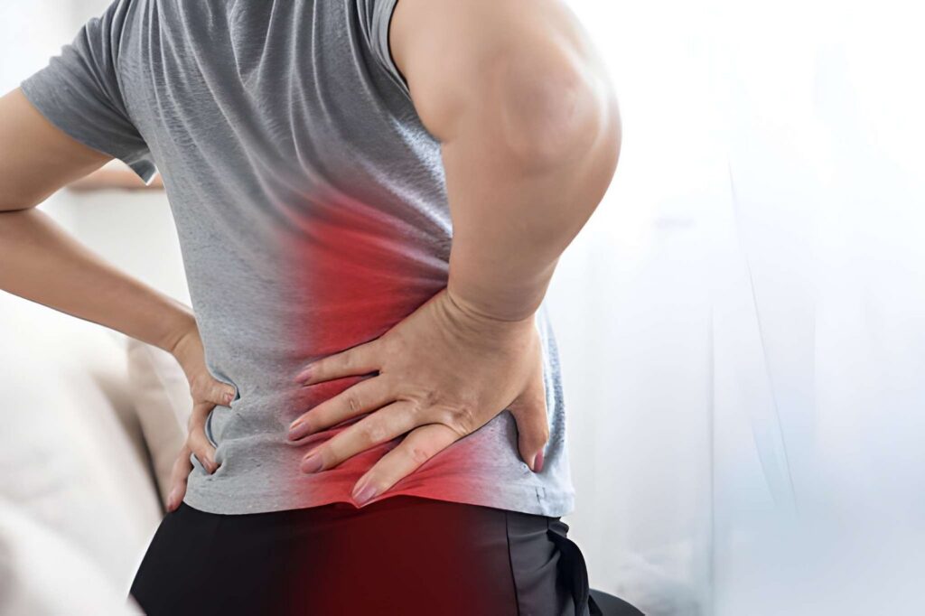 Person holding lower back in pain