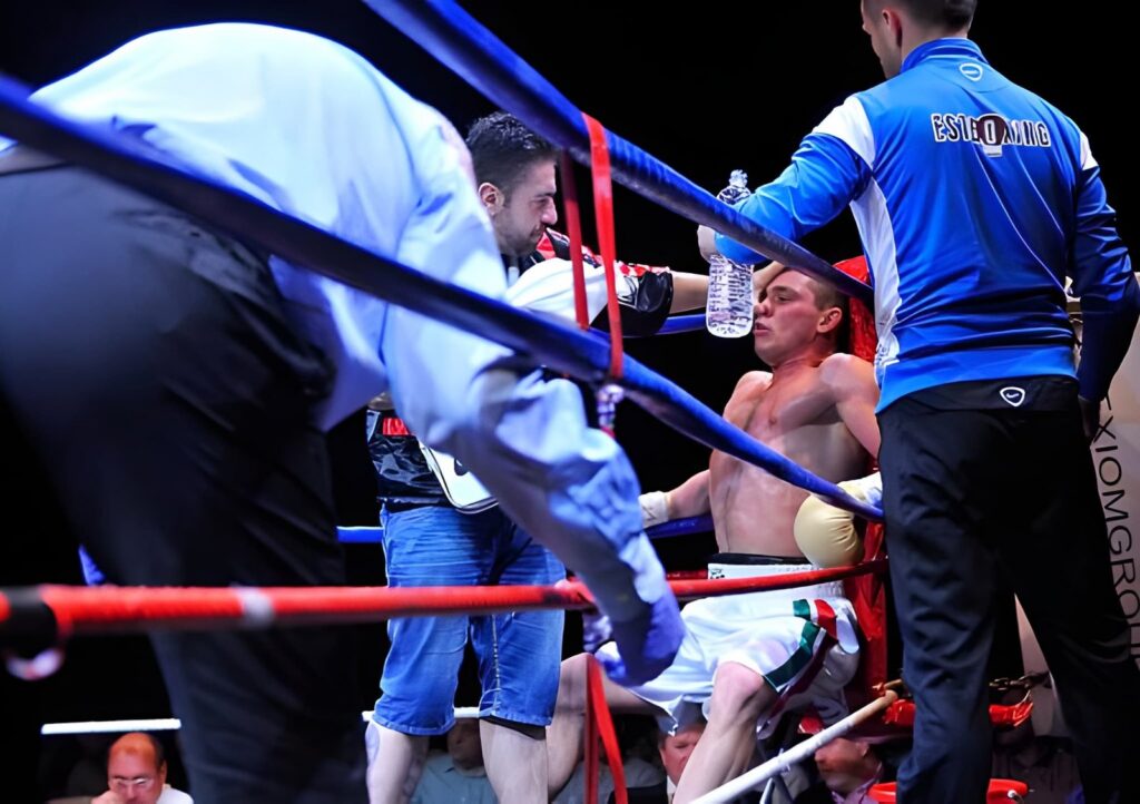 Boxer receiving water in corner between rounds