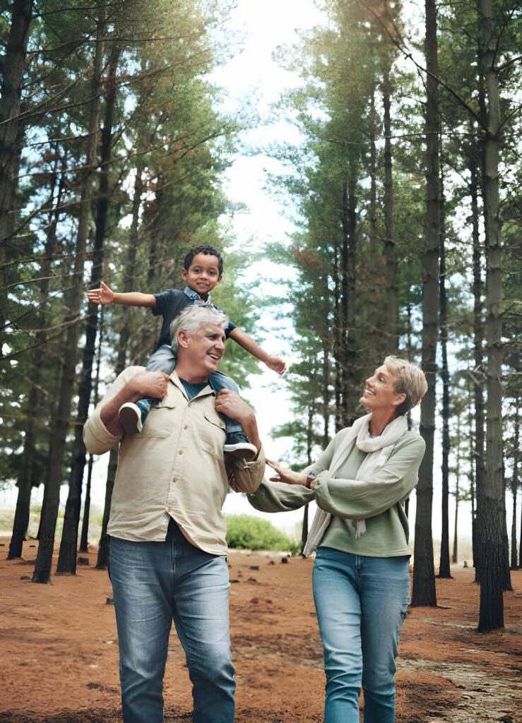 Grandparents walking with child in pine forest