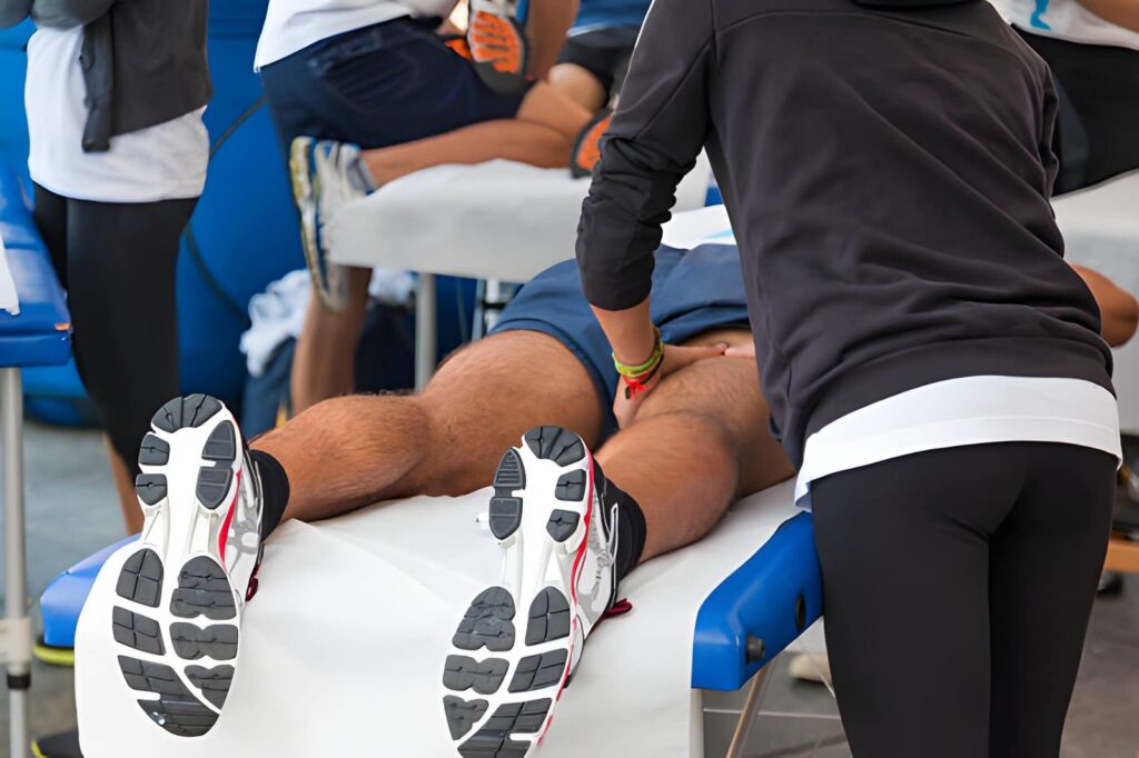 Athlete receiving leg massage on treatment table