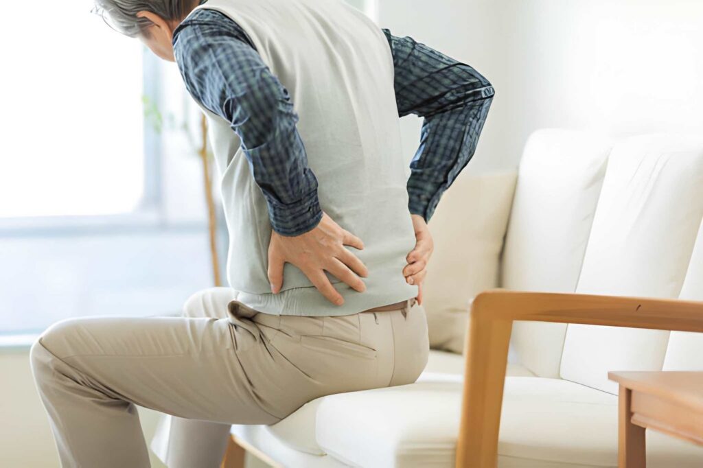 Person sitting on couch with back pain