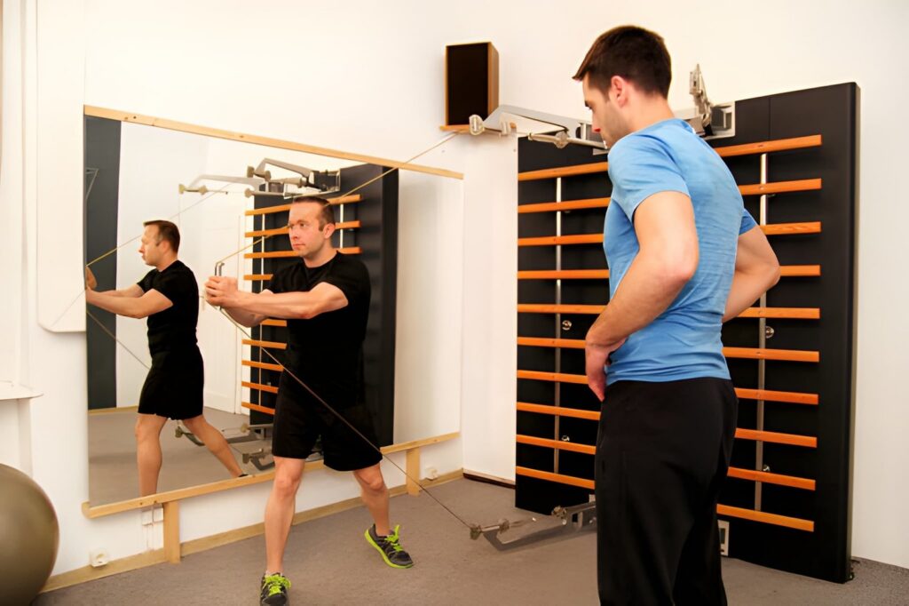 Trainer watching client perform cable exercise