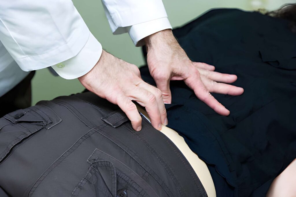 Doctor examining patient's lower back