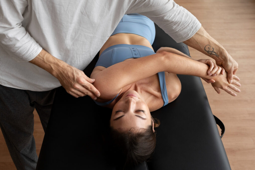 Physical therapist assisting woman with shoulder stretch